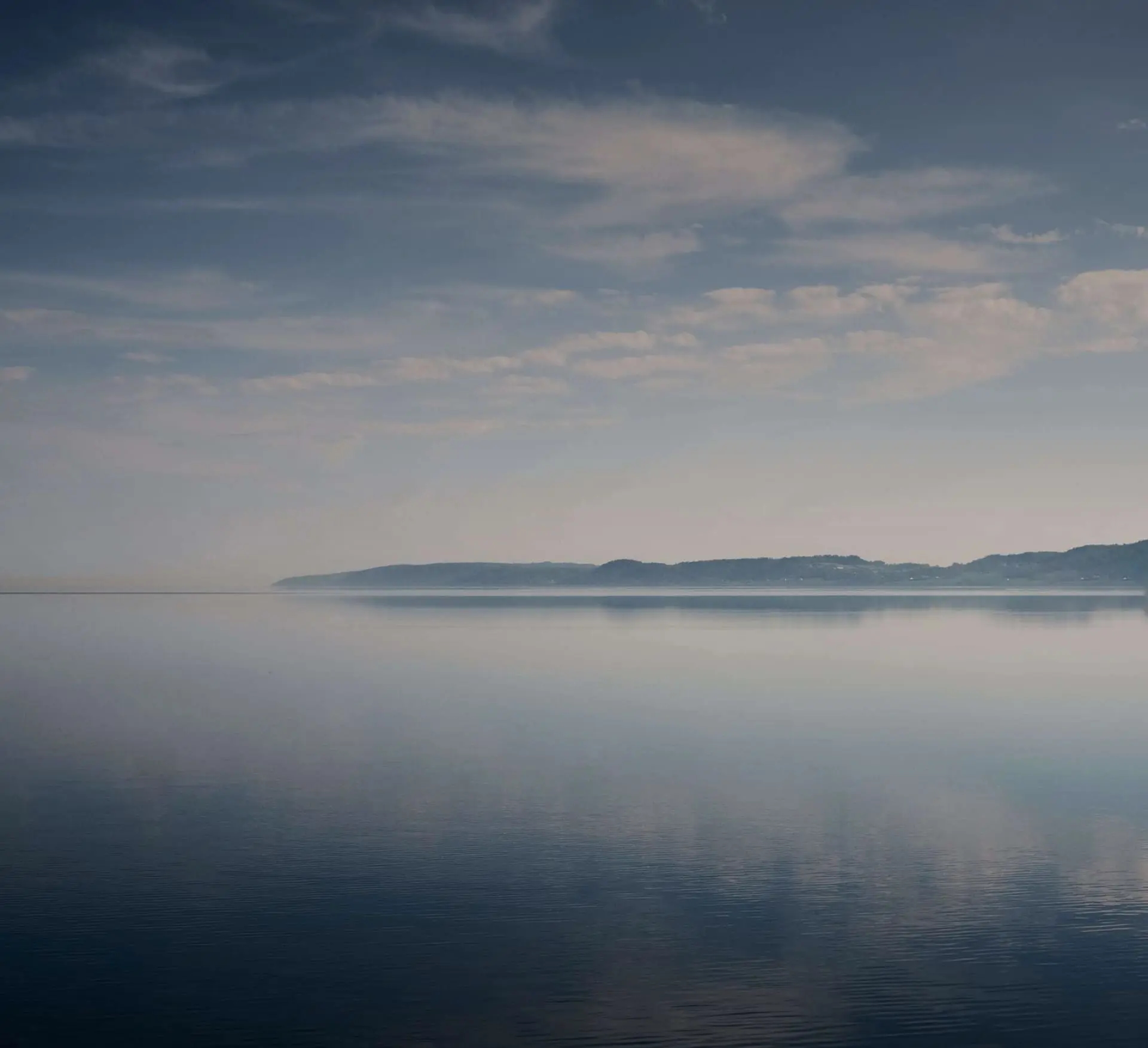 Небо, отражающееся в водоеме, вдалеке видны горы
